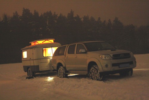 Hilux mit Wohnwägelchen im Schnee. Nachtaufnahme.