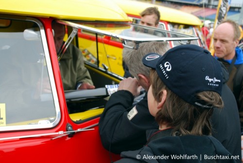 Jochen Mass sitzt im gerade enthüllten Bosch-Bulli und schreibt Autogramme